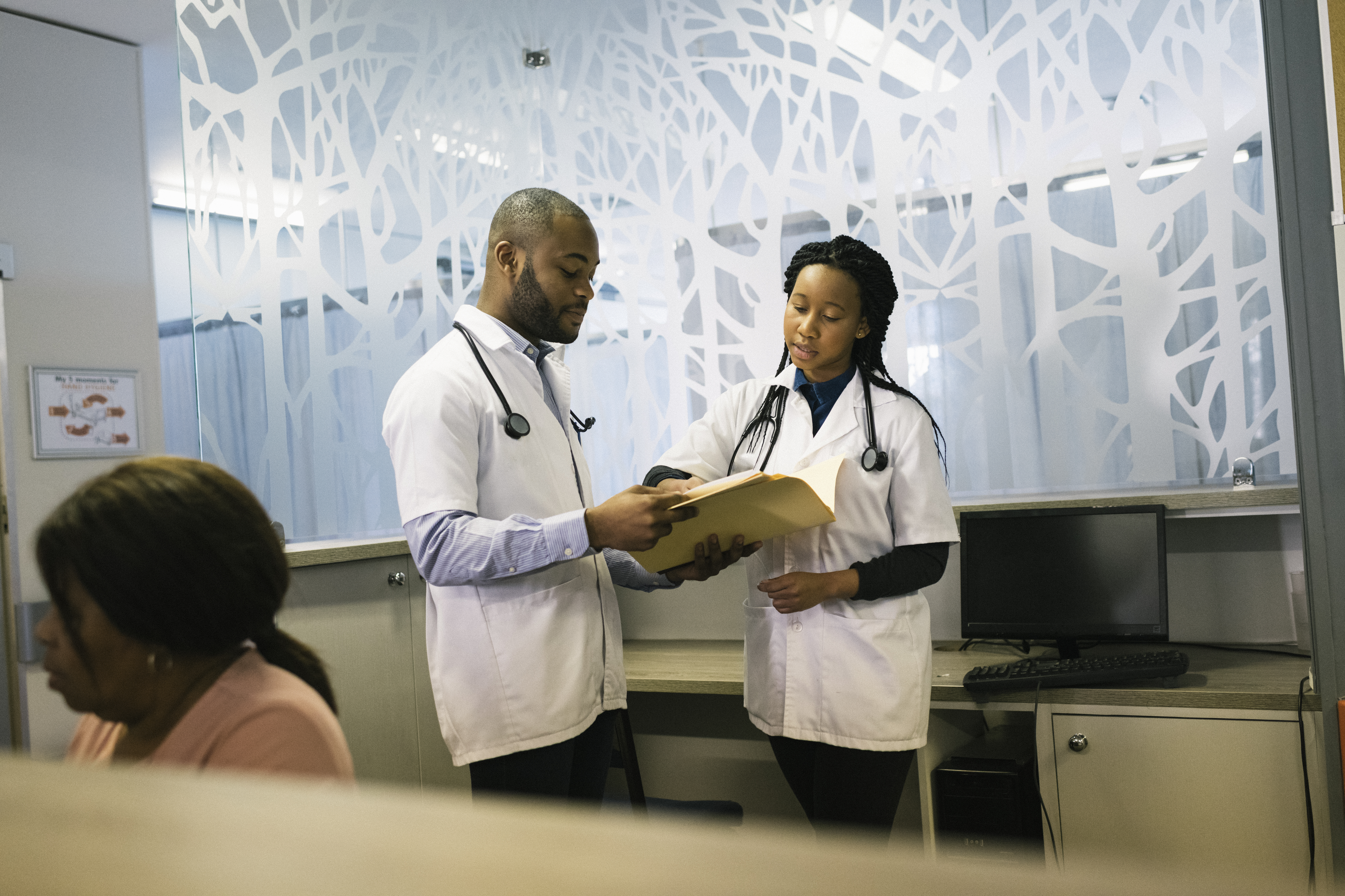 Young African doctors discussing files in clinic reception