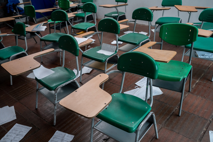 Empty classroom with papers on the floor at a school