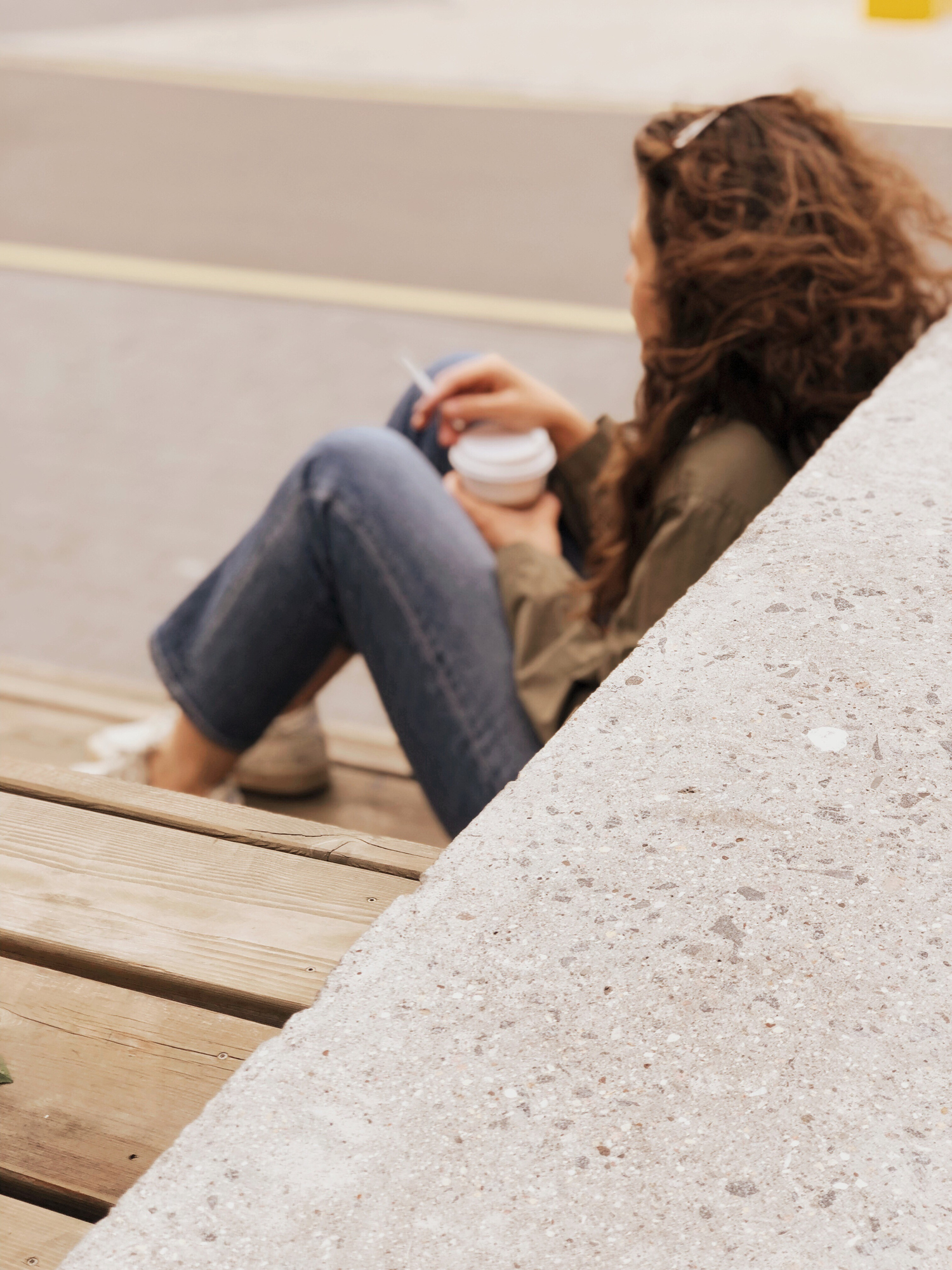 Full Length Of Woman Smoking Cigarette While Sitting By Wall