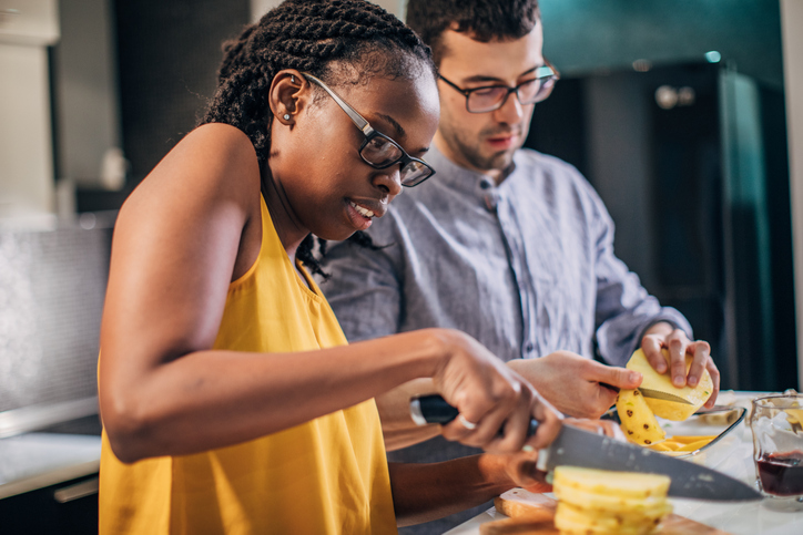 Young couple making fruit salad
